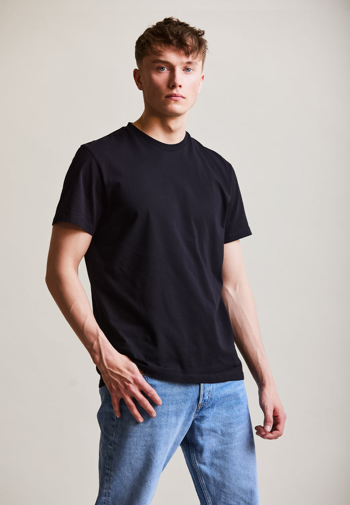 ["Black", "Classic", " Männliches Model trägt classic T-Shirt Black Vorderansicht"]