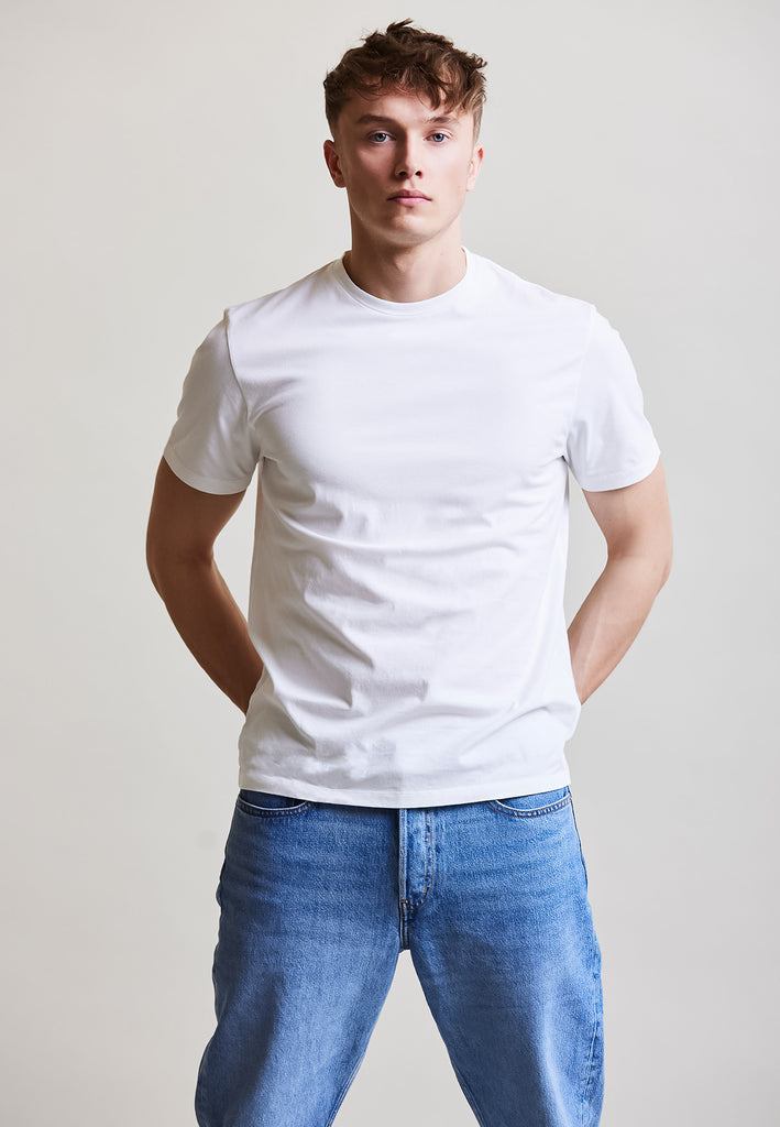 ["White", "Classic", " Männliches Model trägt classic T-Shirt Weiß Vorderansicht"]