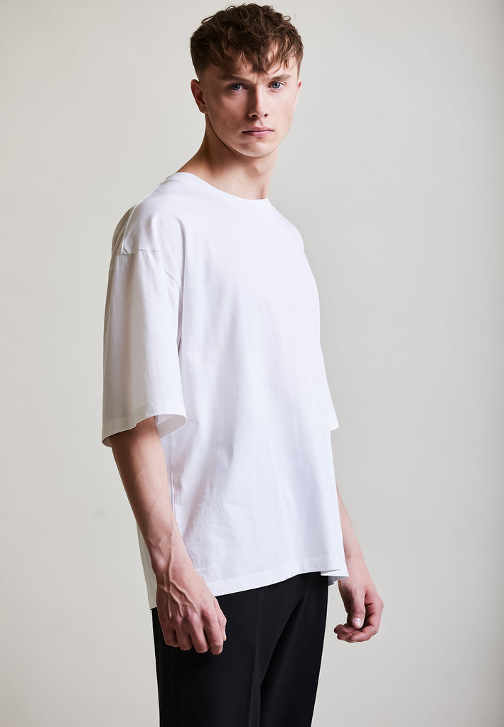 ["White", "Oversize", " Männliches Model trägt oversize T-Shirt White Seitenansicht"]