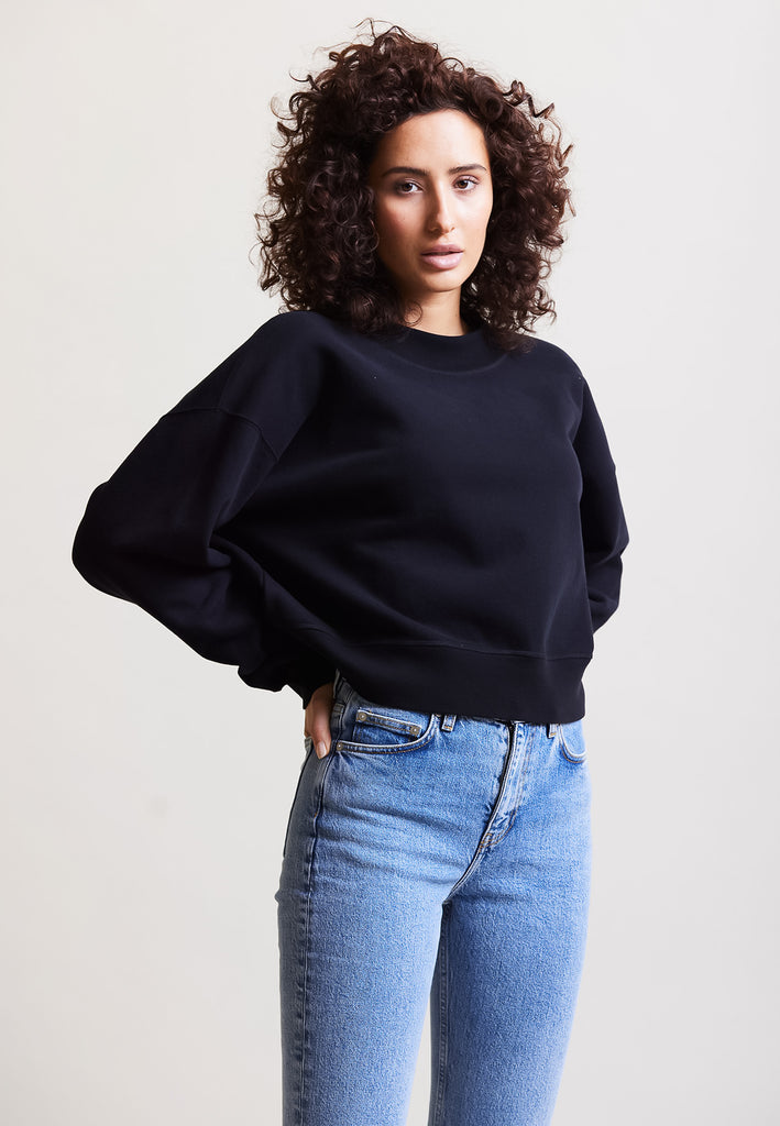 ["Black", " Model trägt Cropped Sweater in Schwarz Vorderansicht"]