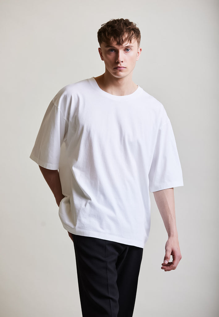 ["White", "Oversize", " Männliches Model trägt oversize T-Shirt White Vorderansicht"]
