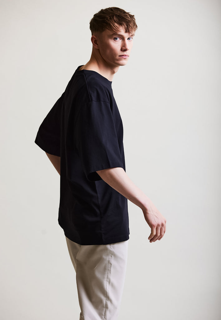 ["Black", "Oversize", " Männliches Model trägt oversize T-Shirt Black Seitenansicht No.2"]