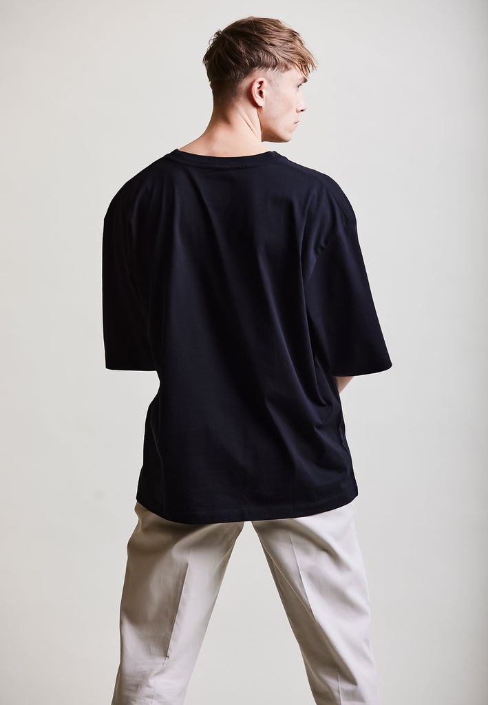 ["Black", "Oversize", " Männliches Model trägt oversize T-Shirt Black Rückansicht"]