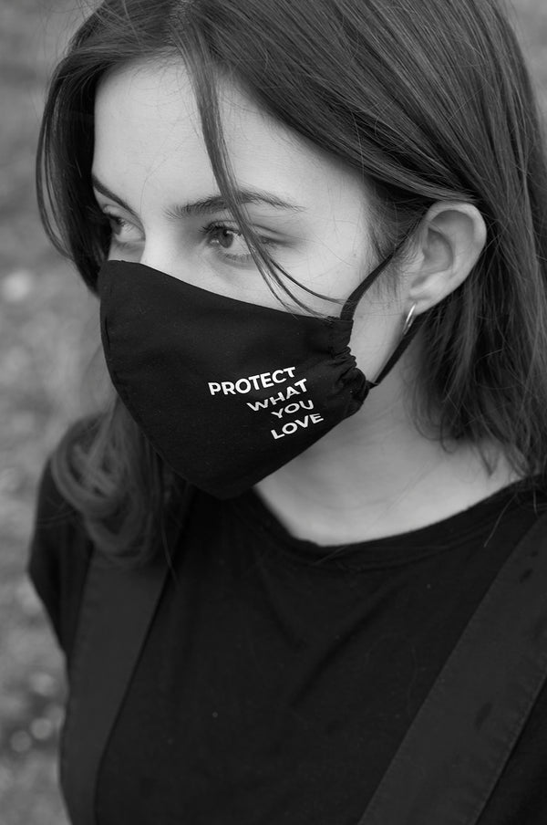 Model trägt Gesichtsmaske schwarz mit protect what you love print