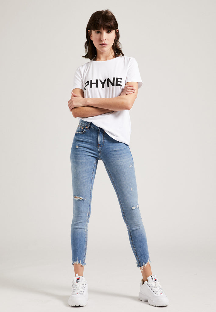 ["Model trägt PHYNE Statement T-Shirt weiß Ganzkörperbild"]
